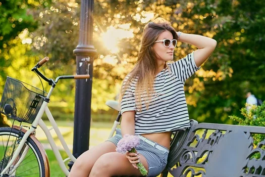 portrait attractive brunette sits bench with bicycle city park